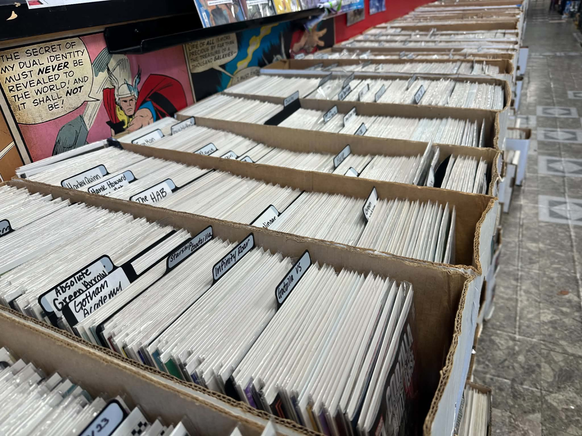 Rows of back-issue boxes packed with comics at Mac's Heroes & Villains